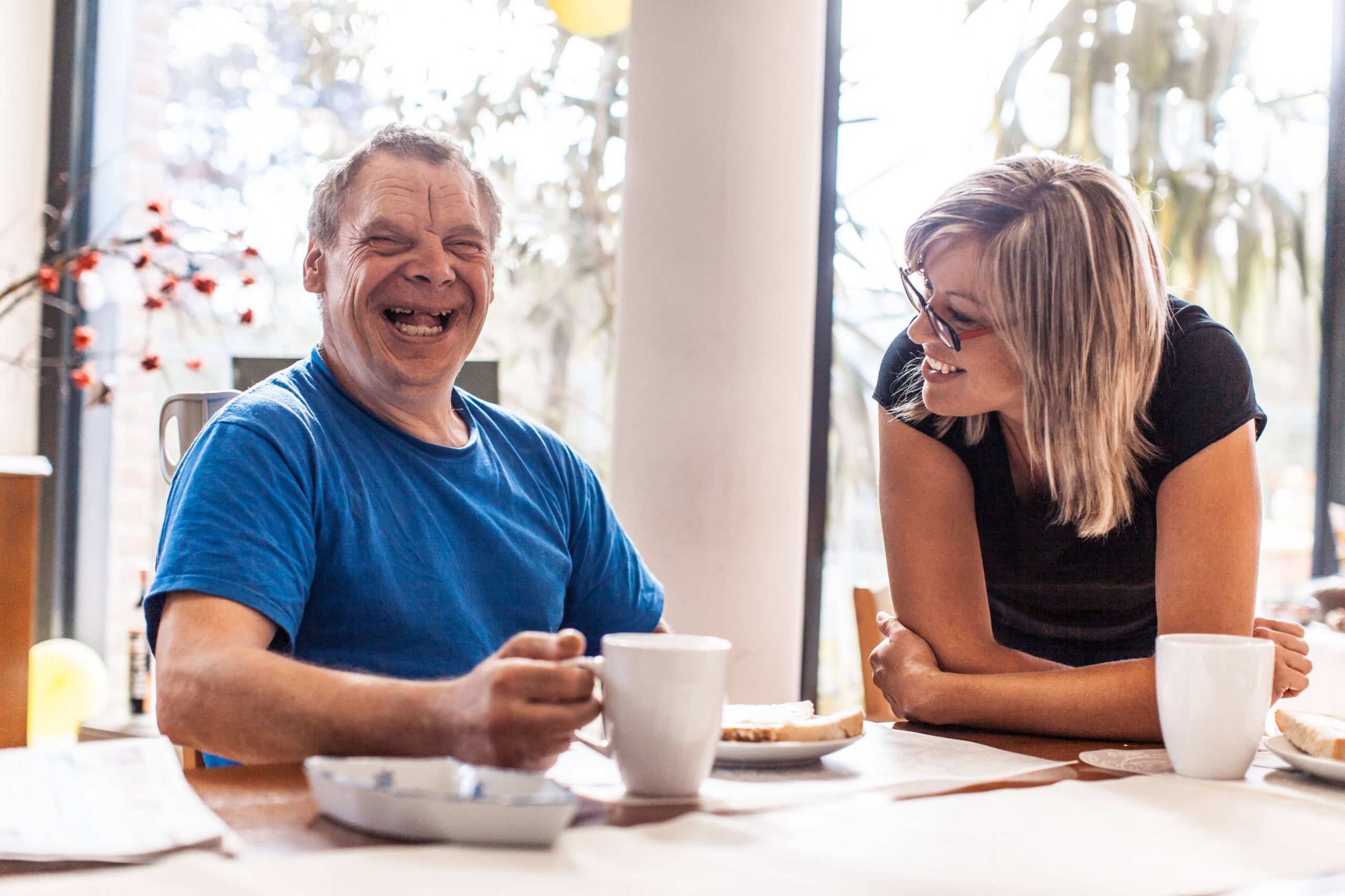 Man with disability having coffee with support worker