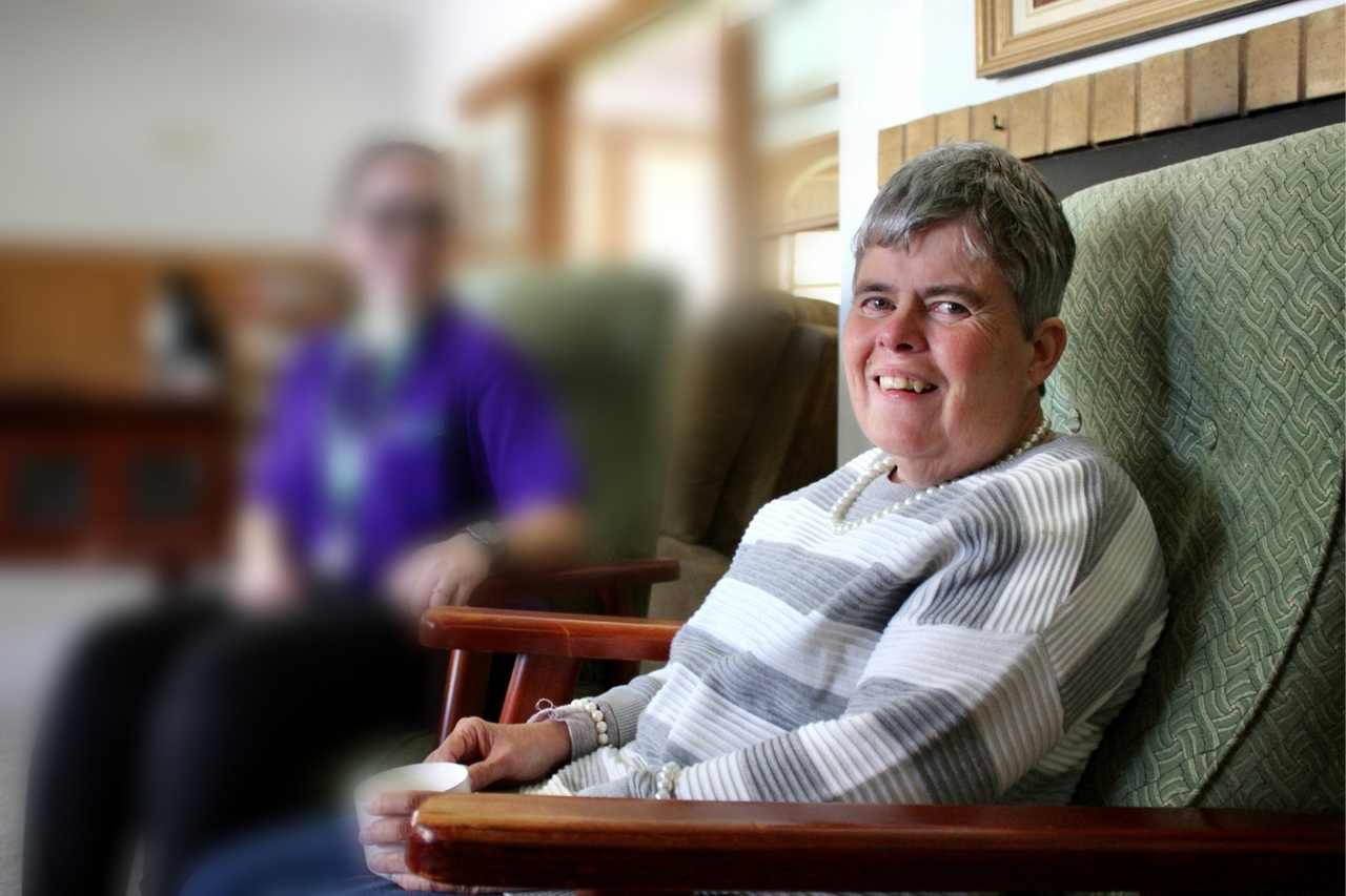 Woman with disability and support worker in a lounge room